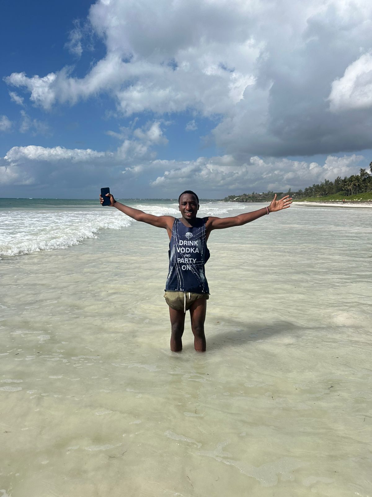 Ian standing in the ocean with arms wide open